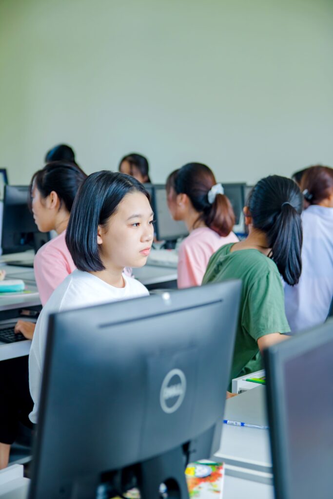 Students focused on learning in a modern computer lab setting.